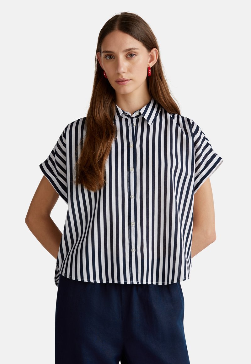 Camicetta a righe navy e bianche con maniche corte, design con bottoni, caratterizzata da un colletto e un fit rilassato. Tessuto morbido e leggero.