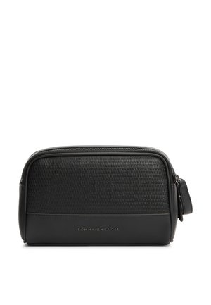 Geantă neagră dreptunghiulară pentru articole de toaletă, cu jumătatea superioară texturată, jumătatea inferioară netedă, fermoar în partea de sus și un mic logo Tommy Hilfiger pe față.