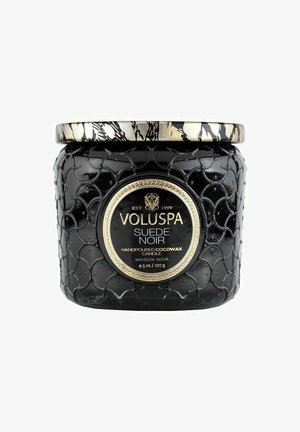 Sort glass lysestage med et struktureret skæl mønster, gyldne detaljer og en rund etiket. Låget har et blomsterdesign i sort og guld.