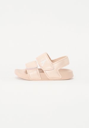 Beige sandal med åben tå, to justerbare velcroremme og en bagrem, designet til komfort og afslappet brug.