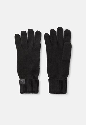 Gants en tricot noirs avec bords côtelés, fabriqués à partir de matériau doux. Design à cinq doigts, avec une étiquette de marque subtile cousue sur un bord.