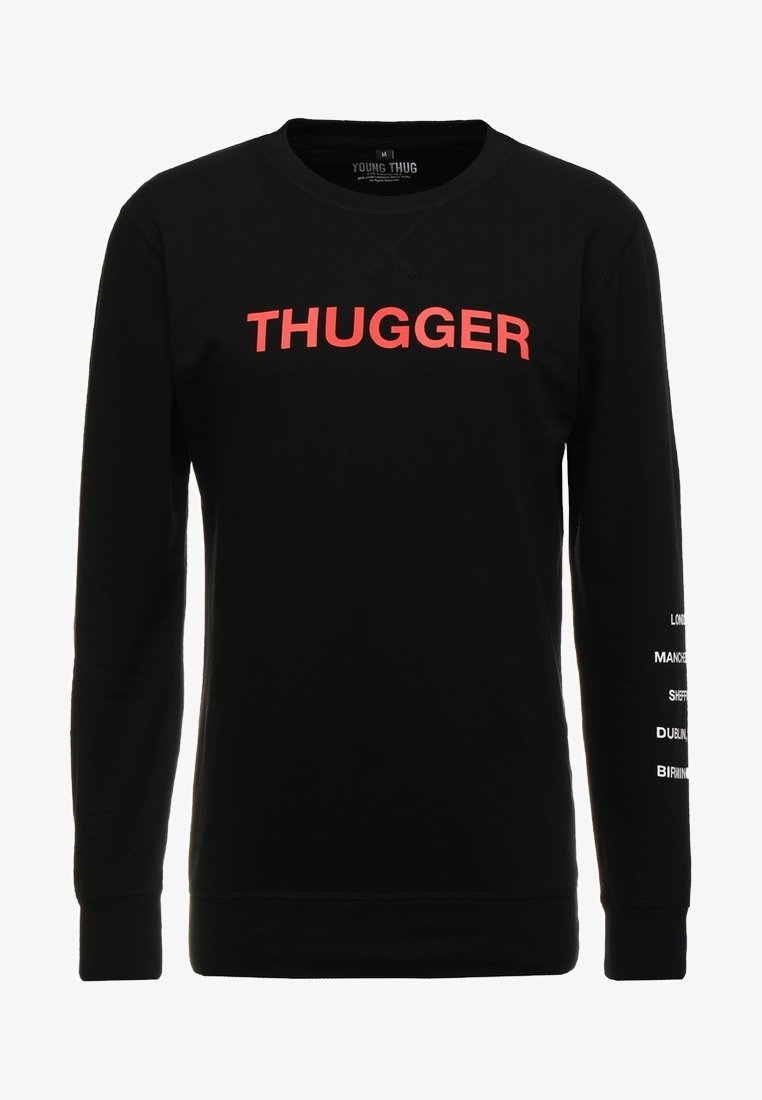 Sweat-shirt noir à manches longues avec le texte rouge "THUGGER" sur la poitrine et des noms de villes blancs imprimés verticalement sur la manche droite.