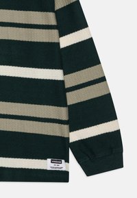 Maglione a maniche lunghe a righe nei colori verde scuro, beige e bianco sporco, con lavorazione a maglia testurizzata. Include un'etichetta del marchio sull'orlo.