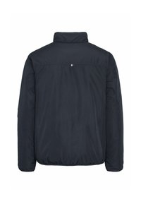 Veste matelassée bleu marine foncé vue de dos avec un petit logo rectangulaire rouge, blanc et bleu sous le col.