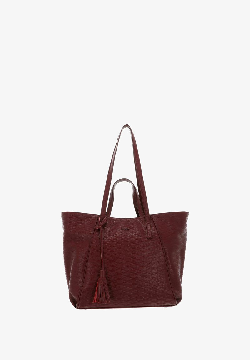 Sac fourre-tout bordeaux en cuir texturé, avec des motifs en forme de losange diagonaux, deux longues poignées et un ornement de pompon sur un côté.