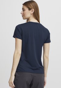 Jūras spēku zilas krāsas īsām piedurknēm T-krekls ar teksturētu rakstu, apaļu kakla izgriezumu un izliekta apakšmalu; viegla auduma ar nelielu stiepjamību.