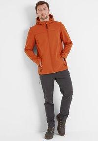 Orange zip-up jacket with a hood, two side pockets, and toggles; paired with dark gray pants and brown hiking boots. Smooth texture.