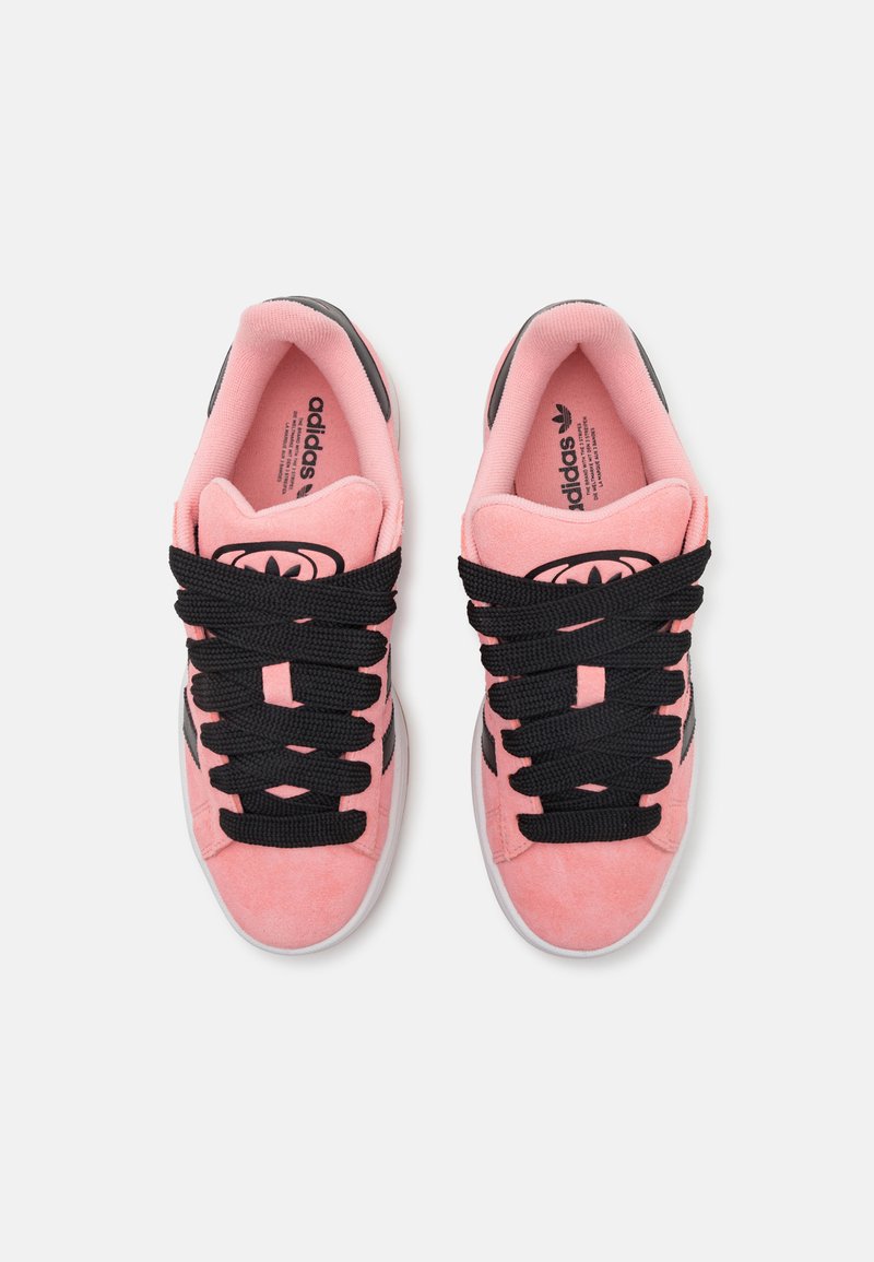 Rosa Wildledersneaker mit schwarzen Schnürsenkeln, sportlichem Design, runder Zehenpartie und klassischen drei Streifen an den Seiten.