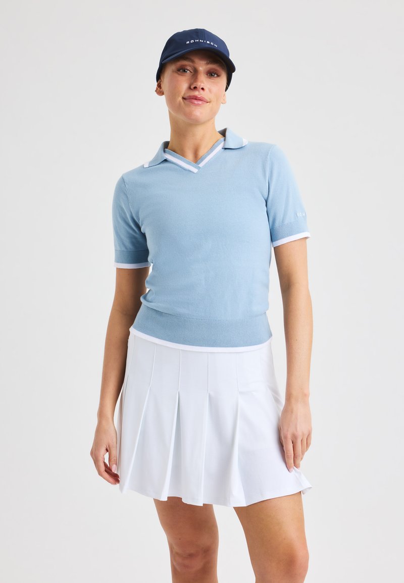 Jasnoniebieska koszulka polo krótki rękaw z dekoltem w kształcie V, białym wykończeniem oraz dopasowaną talią, w połączeniu z białą spódnicą plisowaną.