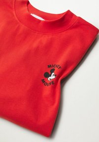 Czerwona bawełniana koszulka z okrągłym dekoltem, z czarną grafiką Myszki Miki i tekstem po lewej stronie. Miękka tekstura i casualowy design.
