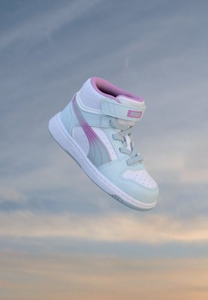 Basket montante Puma bleu clair et blanc avec des accents et lacets roses flottant sur un fond de ciel nuageux.