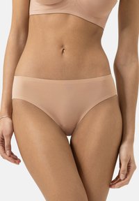 Slip hipster nudo senza cuciture, texture morbida e liscia, design a vita bassa con copertura minima, caratterizzato da una silhouette semplice e pulita.