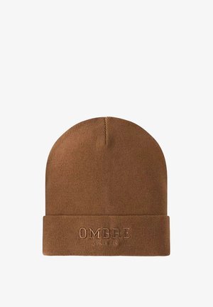 Brun stickad mössa med vik som har ordet "OMBRE" och "SINCE 1955" präglat på framsidan med matchande tråd.