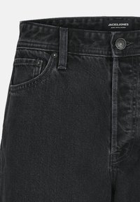 Zwarte denim jeans met een slim fit, voorzien van een platte voorkant, vijf-pocket ontwerp en metalen knoopsluiting. Gestructureerde stof met een lichte glans.