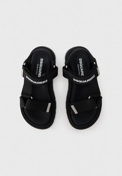 Μαύρα σανδάλια με παχύ, ελαστικό πέλμα, ρυθμιζόμενους ιμάντες, αξεσουάρ σε ασημί τόνο και λογότυπο στο επάνω ιμάντα.