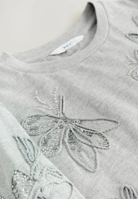 Grijze katoenen sweatshirt met gedetailleerde zilveren kralen en pailletten borduursel van een vlinder op de voorkant. Label leest "NEXT."