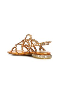 Sandali in pelle color cuoio con un design decorativo, caratterizzati da ritagli circolari e scintillanti strass. Tacco chunky trasparente per un buon supporto.
