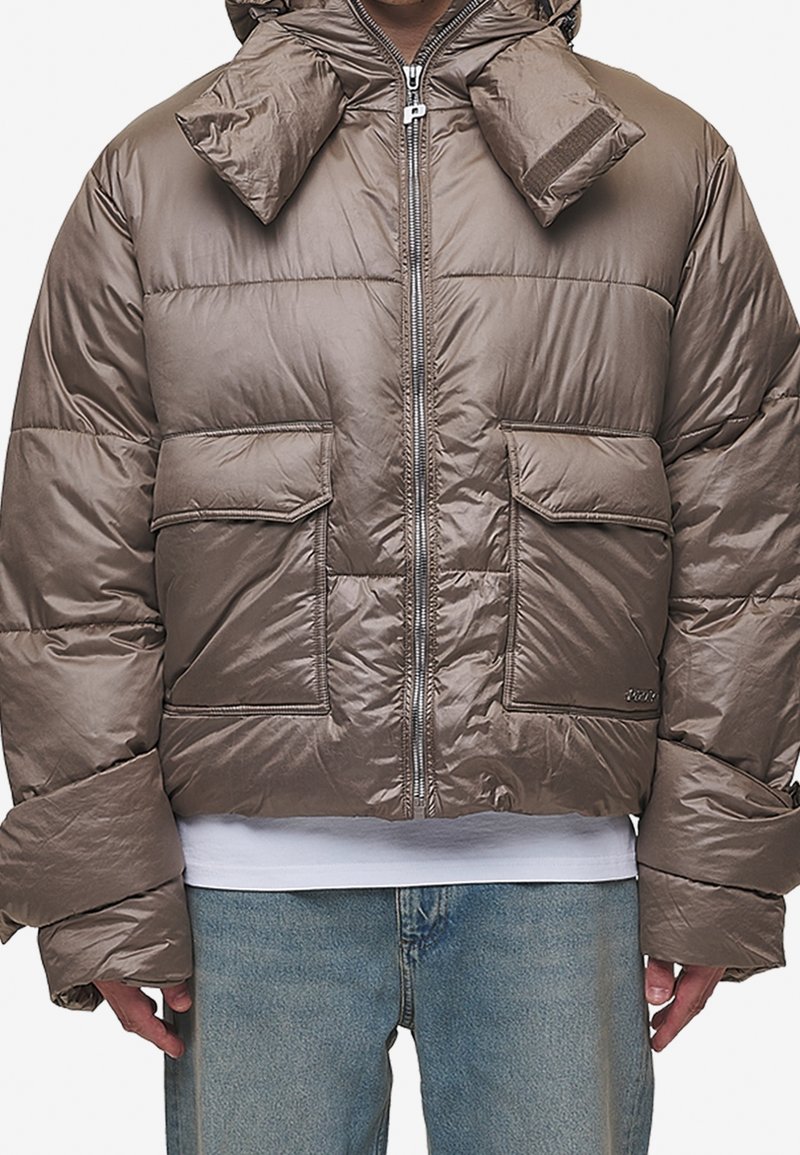 Veste matelassée marron avec une finition brillante, dotée d'un col montant, de deux poches avant et de manches élastiquées pour plus de chaleur.