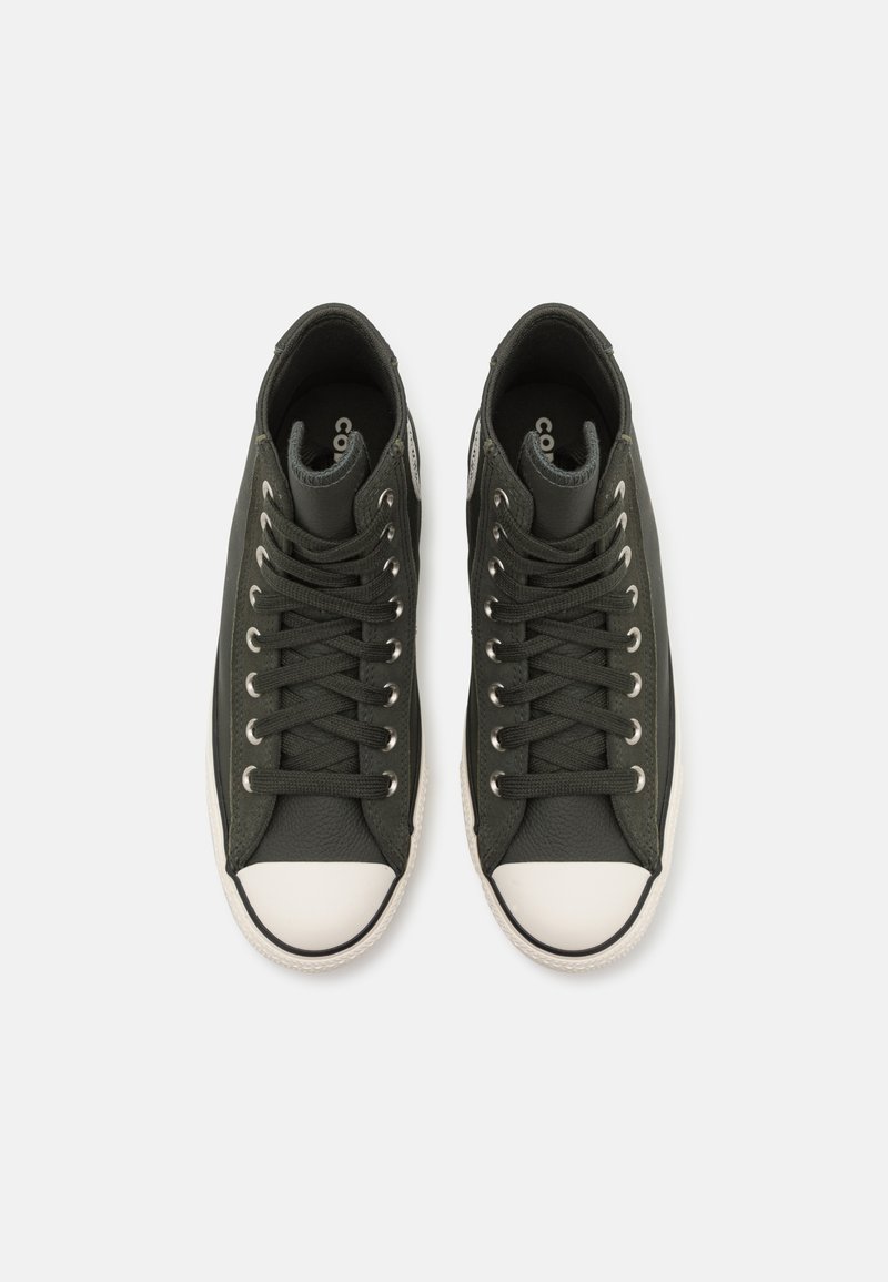 Baskets montantes noires en toile avec un embout en caoutchouc blanc, œillets métalliques et lacets noirs assortis. Tige texturée et col rembourré.