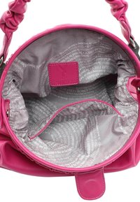 Sac à main rond rose avec poignée froncée montrant un tissu intérieur gris imprimé de texte et une étiquette de marque rose cousue à l'intérieur.