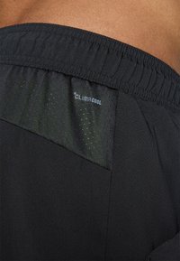 Shorts de sport noirs avec une taille élastique, dotés d'une poche en maille respirante. Marquage "ClimaCool" visible sur le côté.