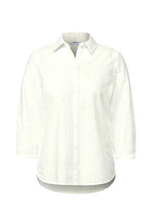 Camicia bianca con maniche a tre quarti, caratterizzata da un tessuto testurizzato con ricami a occhiello e un orlo leggermente curvo.