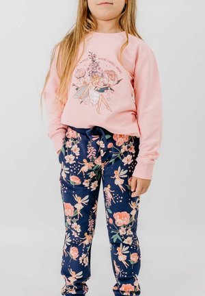 Young girl wearing a pink sweatshirt with a fairy and flowers design, paired with navy pants featuring a pink floral and fairy pattern.
