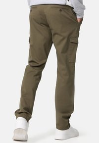 Pantalones cargo verde oliva de algodón con bolsillos laterales y un diseño de pierna recta. Con cierres de botón y una textura suave.