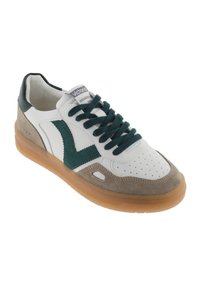 Sneaker in pelle bianca con dettagli in suede verde, punta perforata e lacci teal scuri. Presenta una suola in gomma color beige e un logo sulla linguetta.