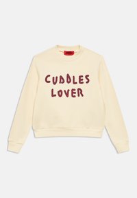 Kreminės spalvos džemperis ilgomis rankovėmis su bordo spalvos užrašu „CUDDLES LOVER“ priekyje, turi gofruotą apykaklę, rankogalius ir apačią.