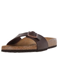 Sandalo in cuoio marrone con fibbia regolabile, soletta in sughero naturale e suola in gomma testurizzata per una buona aderenza. Punta aperta e design minimalista.