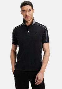 Polo shirt noir avec un col gris, détails en piping blanc et une patte de boutonnage à trois boutons. Présente un petit logo sur la poitrine et des manches courtes.