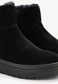 Fekete velúr bokacipők sima felülettel, oldalsó cipzárral és gumitalppal, amelynek taposó mintázata van a tapadás érdekében. Bélése melegít.