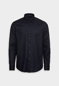 Camicia nera a maniche lunghe realizzata in tessuto morbido, con colletto a camicia, bottoni blu e un piccolo logo sul petto sinistro.