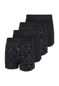 Quattro boxer neri con elastico in vita, due con motivi floreali scuri e due semplici, disposti in una fila sfalsata.