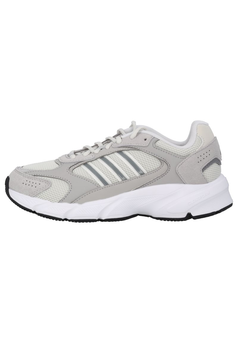 Scarpa sportiva grigia chiara con tomaia in mesh e sintetico, accentuata da dettagli bianchi, tre strisce metalliche sul lato e suola nera texture.