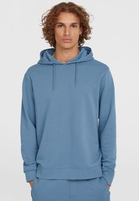 Light blue hoodie made from soft fabric, featuring a drawstring hood, ribbed cuffs, and a small embossed logo on the chest.