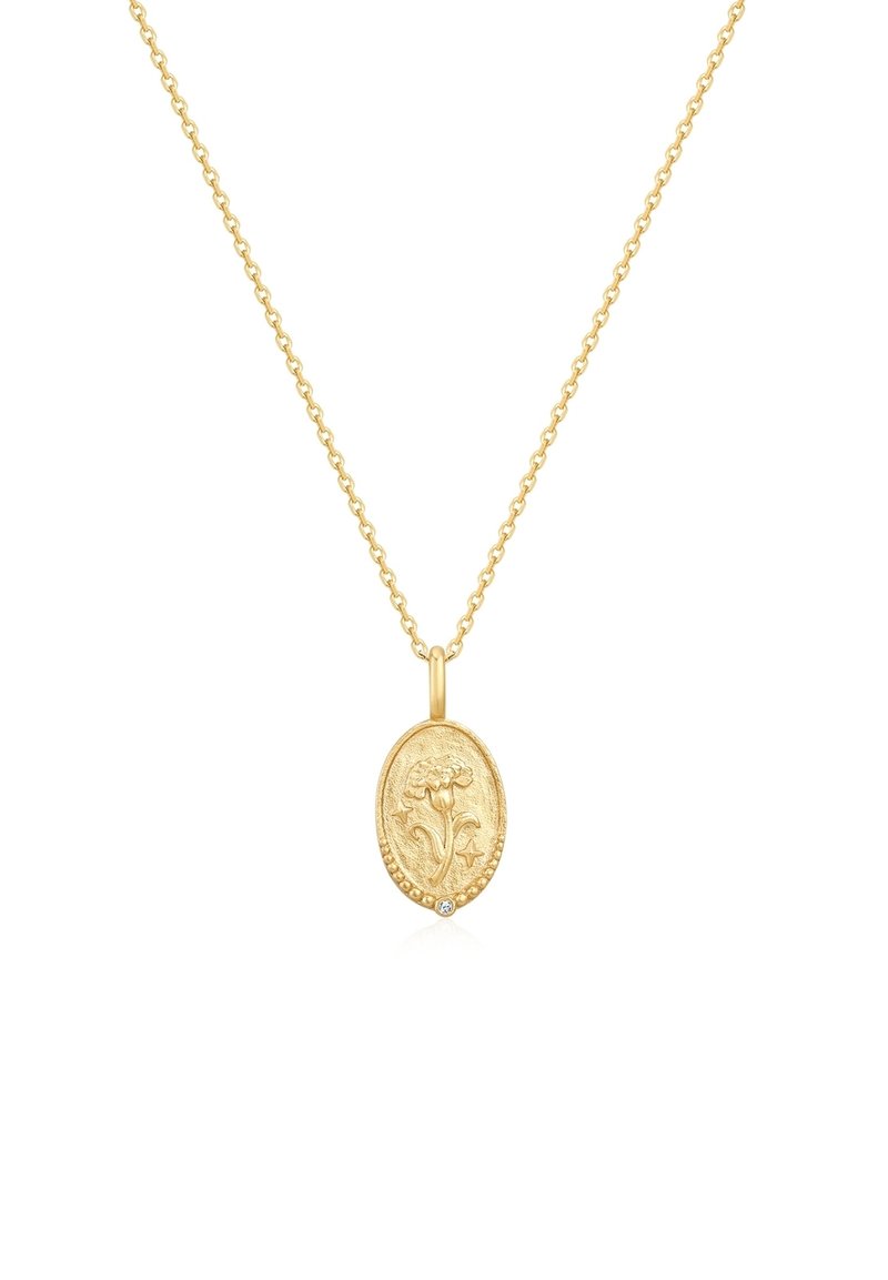 Auksinės spalvos vėrinys su ovalo formos pakabuku, papuoštu gėlių raižiniu, papildytu mažu, įmontuotu akmeniu. Grandinėlės dizainas.