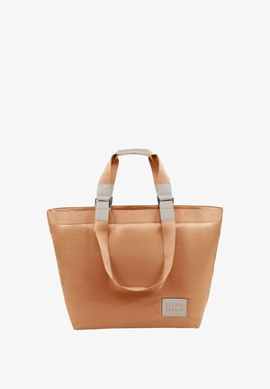 Peachfarvet stofpose lavet af glat materiale, med beige håndtag, grå hårdvare accenter og et syet mærke på fronten.