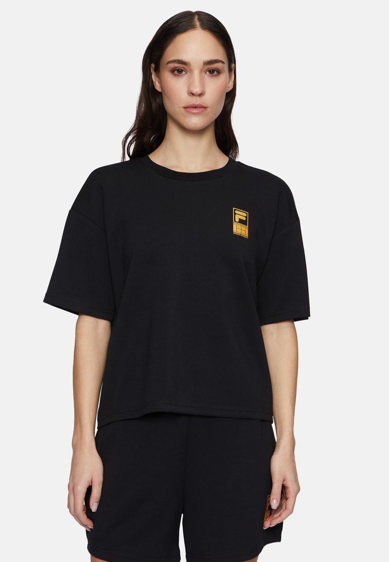 Zwarte oversized t-shirt van katoen, met een gouden logo op de linkerborst, ronde halslijn en korte mouwen. Eenvoudig en casual ontwerp.