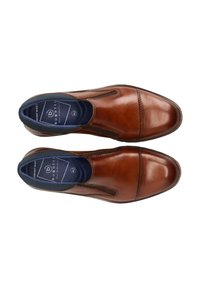 Pair of brown leather slip-on men's dress shoes with elastic side panels and navy inner lining labeled "bugatti" size 42, shoes positioned top view.