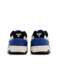 Baskets noires et bleues avec une semelle blanche, présentant des panneaux texturés et un logo d'abeille sur le talon. Matériaux en tissu et cuir utilisés.