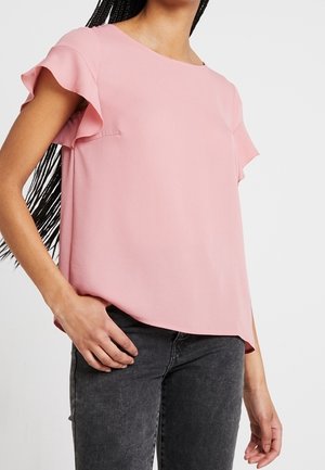 Blusa rosa a maniche corte con spalle volant, realizzata in tessuto morbido, caratterizzata da una vestibilità ampia e scollatura rotonda.
