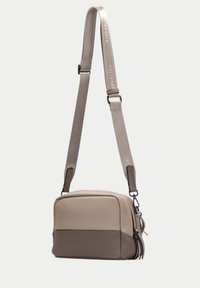 Obdélníková crossbody taška ve světle béžové kůži s tmavohnědým dnem. Obsahuje nastavitelné ramenní popruhy a zipové uzavření.
