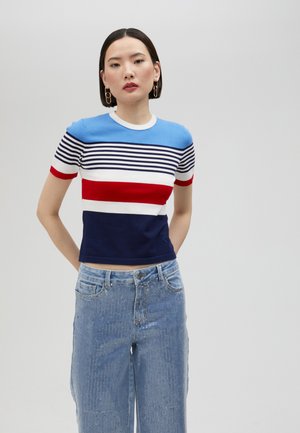 Gestreiftes Kurzarmstrickoberteil in Blau, Weiß, Rot und Marine; schlanker Schnitt; Rundhalsausschnitt; verfügt über unterschiedlich breite Streifen. Getragen mit hochtaillierten Jeans.