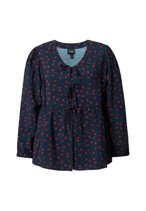Blouse marine avec motif de nœuds rouges, décolleté en V et cordon sous la poitrine. Elle présente des manches bouffantes et une taille froncée pour un ajustement décontracté.