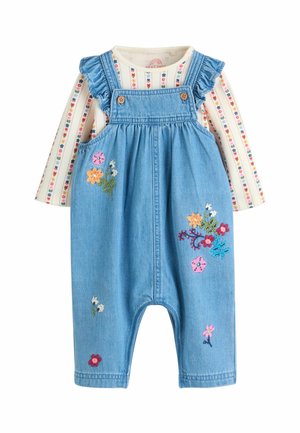 Farmer overál fodros pántokkal, gombokkal és színes virágmintával. Csíkos, hosszú ujjú pólóval párosítva.