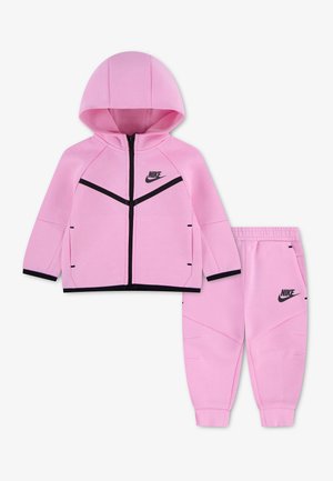 Pinkfarbener Nike Kinder-Trainingsanzug mit Kapuzen-Zip-Jacke und passenden elastischen Bundhosen, mit schwarzem Logo und Besatzdetails.