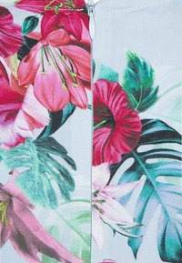 Tkanina w kwiatowy wzór z różowymi i zielonymi tropikalnymi kwiatami oraz liśćmi, z zamkiem błyskawicznym w kolorze srebrnym na środku.