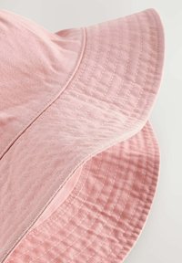 Pink bomuldsbuket med en bred, syet skygge, der har et tekstureret mønster og en glat overflade. Accenter inkluderer subtile syninger.